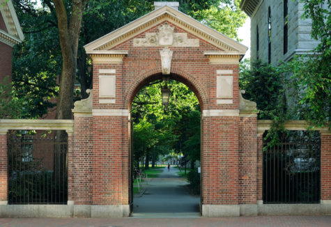 Harvard's gate to a prestigious university campus surrounded by trees