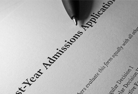 Close-up of a pen resting on a printed first-year college admissions application