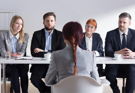 Candidate sitting across from four interviewers during a formal panel interview