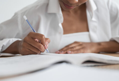 Close-up of a female student writing in a notebook