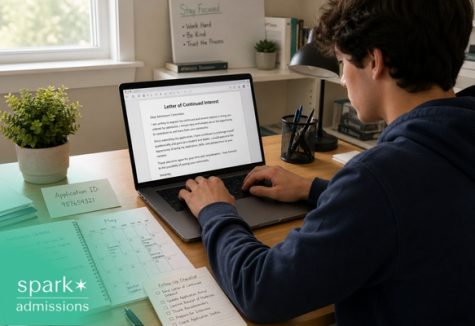 Student writing a letter of continued interest on a laptop at a desk.
